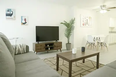 a living room with a flat screen tv on a table at Spacious 2BR Townhouse - 3 Queens - Sleeps 8 in Redondo Beach