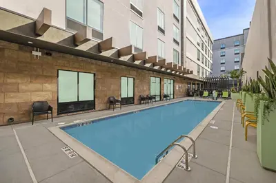a large swimming pool with chairs and a building at Home2 Suites By Hilton Riverside Downtown in Riverside