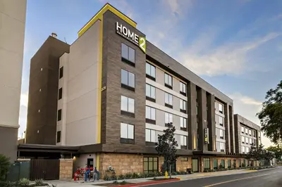 a hotel building with a sign on the side of it at Home2 Suites By Hilton Riverside Downtown in Riverside