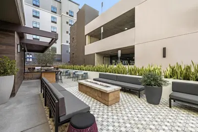 an outdoor patio with couches and a fire pit at Home2 Suites By Hilton Riverside Downtown in Riverside