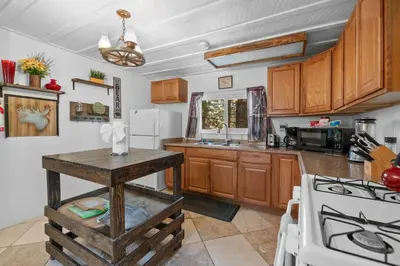 a kitchen with wooden cabinets and a counter top at StoneHauz was built in 1926! It's a REAL CABIN! in Big Bear Lake