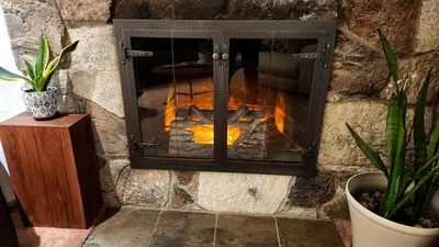 a stone fireplace with a fire in it at Cheerful Single Story 3-bedroom home w pool table in Santa Clarita