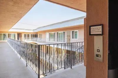 an empty hallway of a building with a metal railing at Steps to Ocean Bliss in Long Beach