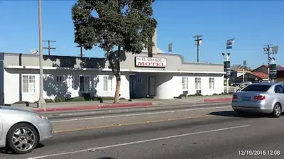 a car parked on the street in front of a motel at El Grande Motel in South Gate