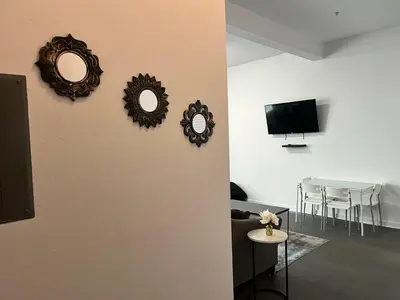 a living room with a table and mirrors on the wall at The NoHo Artist Nook in Burbank