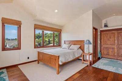 a bedroom with a bed and two windows at Blue Ocean View Retreat - Minutes to Beach in Summerland