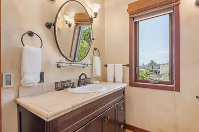 a bathroom with a sink and a mirror and a window at Blue Ocean View Retreat - Minutes to Beach in Summerland