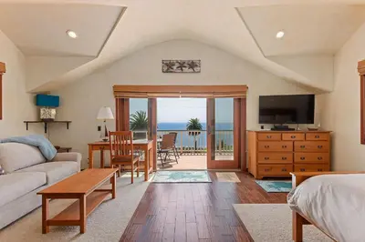 a living room with a couch and a table with a television at Blue Ocean View Retreat - Minutes to Beach in Summerland
