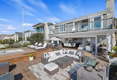 a large house with a patio with white furniture at Seacliff Beach Retreat - Amazing Beachfront for Family of 6 in Ventura