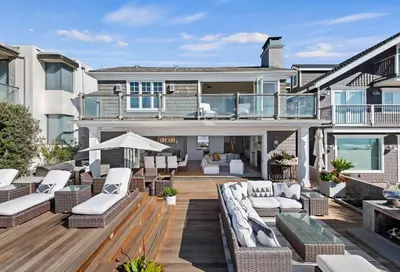 a large house with a patio with white furniture at Seacliff Beach Retreat - Amazing Beachfront for Family of 6 in Ventura