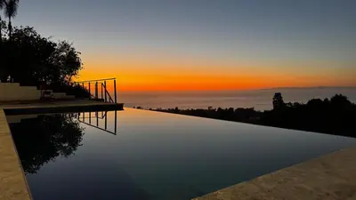 a swimming pool with a sunset in the background at Ocean Vista in Palos Verdes Estates