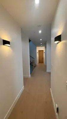 an empty hallway with white walls and wood floors at Ocean Vista in Palos Verdes Estates
