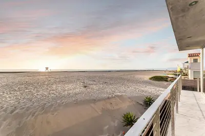 a view of the beach from the balcony of a house at Modern Ocean Front Beach Home- 3 king beds 3 bedroom in Oxnard