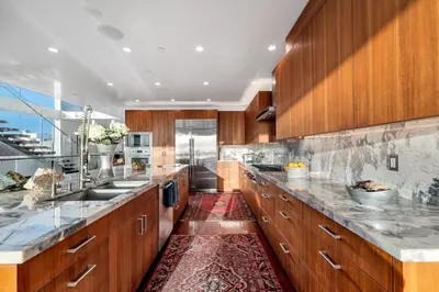 a large kitchen with wooden cabinets and marble counter tops at Modern Ocean Front Beach Home- 3 king beds 3 bedroom in Oxnard