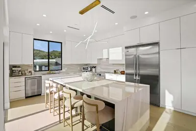 a kitchen with a large island with bar stools at Samara by Stay Awhile Villas in Malibu