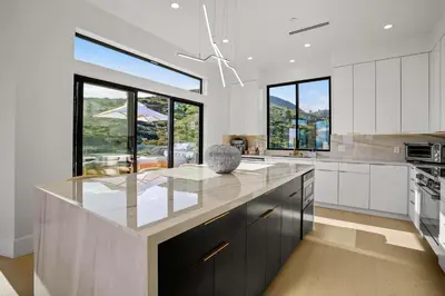 a kitchen with white cabinets and a large island at Samara by Stay Awhile Villas in Malibu