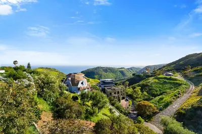 an estate on a hill with the ocean in the background at Samara by Stay Awhile Villas in Malibu