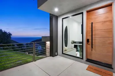 a house with a balcony with a view of the ocean at Samara by Stay Awhile Villas in Malibu