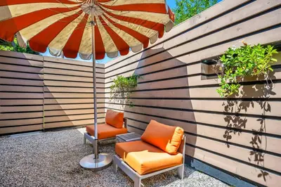 a patio with two chairs and an umbrella at Claudia's Guest House in Los Angeles