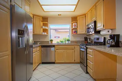 a kitchen with wooden cabinets and a stainless steel refrigerator at F-13 California Dreamin in Anaheim