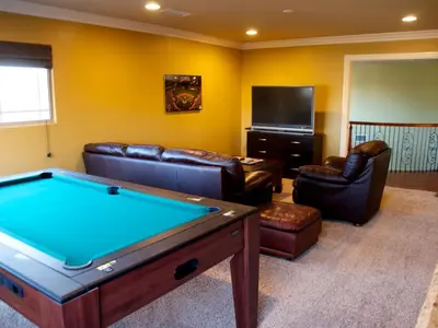 a living room with a pool table and leather furniture at F-25 Belles Castle in Anaheim