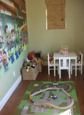 a room with a table and a toy train on a rug at F-25 Belles Castle in Anaheim