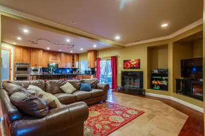 a living room with a leather couch and a kitchen at F-25 Belles Castle in Anaheim