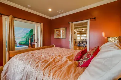 a bedroom with a large bed with red walls at F-25 Belles Castle in Anaheim