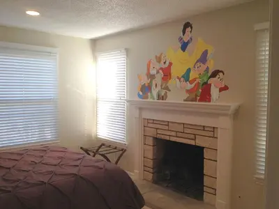 a bedroom with a fireplace with a disney mural on the wall at F-29 The Pirates Cove in Anaheim