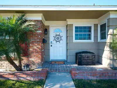 a house with a white door and a palm tree at F-29 The Pirates Cove in Anaheim