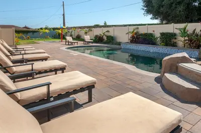 a swimming pool with lounge chairs next to a patio at F-32 La Casa de Mickey in Anaheim
