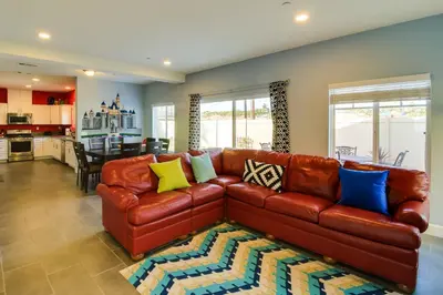 a living room with a brown leather couch with colorful pillows at F-33 Walts Place in Anaheim