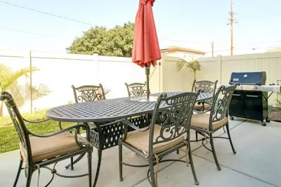 a patio table and chairs with an umbrella and a grill at F-33 Walts Place in Anaheim