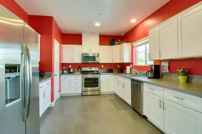 a kitchen with white cabinets and red walls at F-33 Walts Place in Anaheim