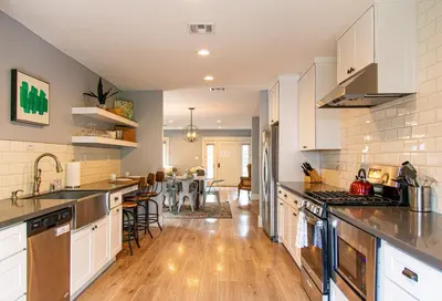a kitchen with white cabinets and a dining room at F-39 Helena in Anaheim