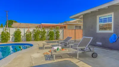a pool with two chairs and a table next to a house at F-53 Trenton in Anaheim