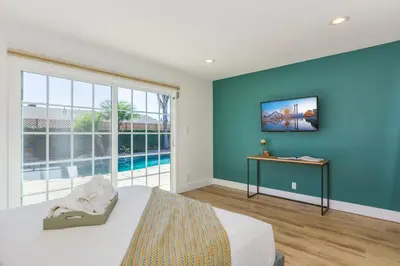 a bedroom with a blue wall with a bed and a pool at F-54 Maverick in Anaheim