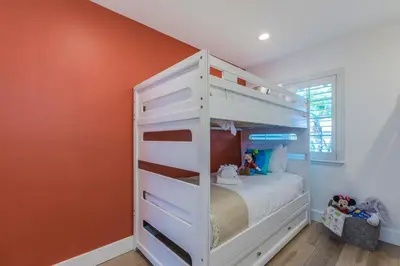 a white bunk bed in a room with an orange wall at F-54 Maverick in Anaheim