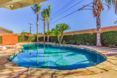 a swimming pool in a yard with palm trees at F-54 Maverick in Anaheim