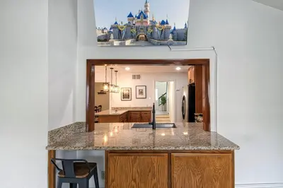 a kitchen and living room with a castle in the background at F-64 California Vibes in Anaheim
