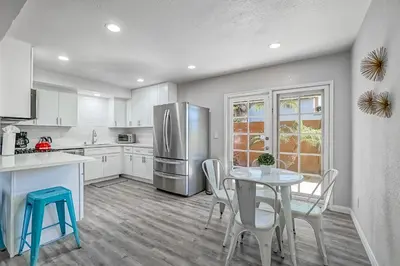 a kitchen with a table and chairs and a refrigerator at F-65 Adventure House in Anaheim