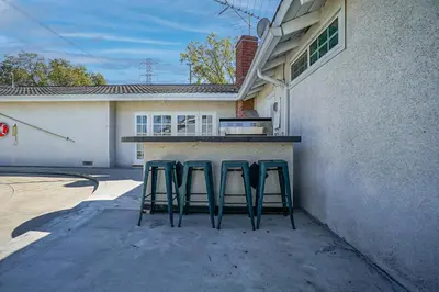 three green stools sitting at a counter in front of a house at F-65 Adventure House in Anaheim