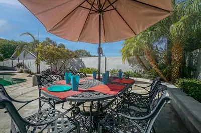 a patio table with an umbrella and a table and chairs at F-65 Adventure House in Anaheim
