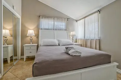 a bedroom with a large bed with two tables and two lamps at F-66 Poolside Retreat in Anaheim