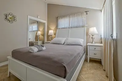 a bedroom with a large bed with two lamps and a mirror at F-66 Poolside Retreat in Anaheim