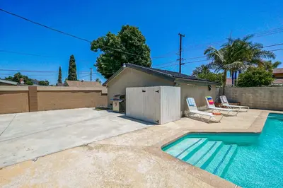 a swimming pool with two chairs next to a house at F-66 Poolside Retreat in Anaheim