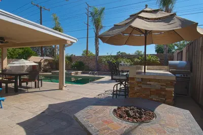 a patio with an umbrella and a fire pit at F-20 Paradise Pier in Anaheim