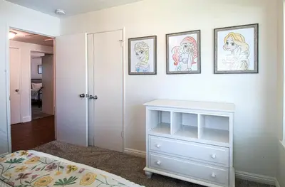 a bedroom with a white dresser and three pictures on the wall at F-22 Castle House 2 in Anaheim