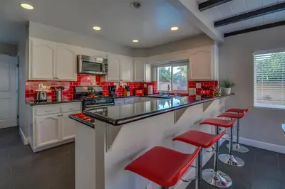a kitchen with red counter tops and red stools at F-24 Mickeys House in Anaheim