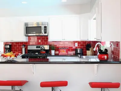 a red and white kitchen with white cabinets and red stools at F-24 Mickeys House in Anaheim